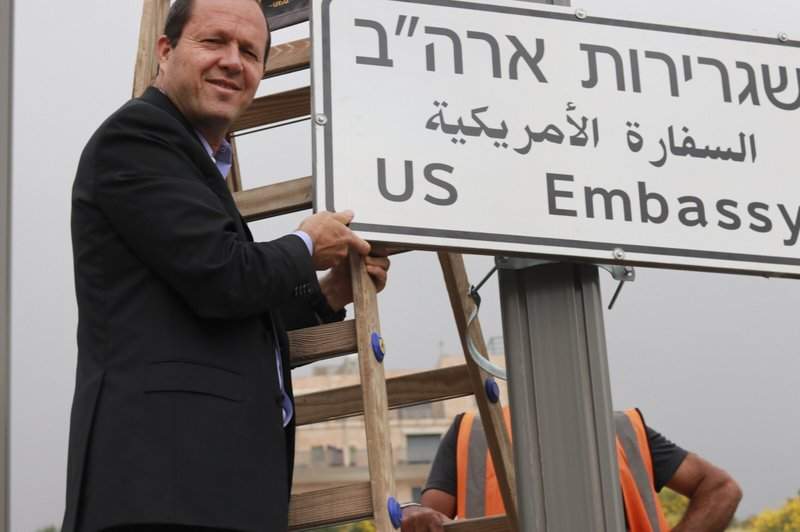 In this photo released by the Jerusalem Municipality, Jerusalem mayor Nir Barkat poses with a new road sign to the new U.S. Embassy in Jerusalem, Monday, May 7, 2018. 