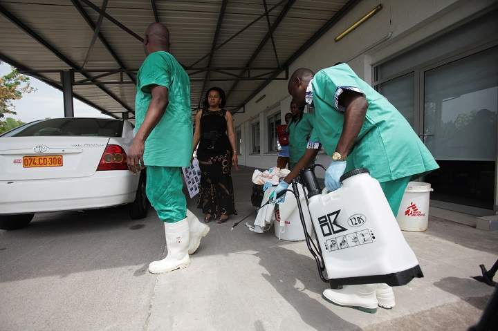 A health worker sprays a colleague with disinfectant during a training session for Congolese health workers to deal with Ebola virus in Kinshasa October 21, 2014. An outbreak of Ebola in the DRC has claimed 17 lives.
