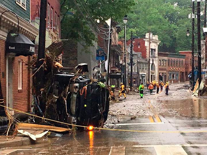 Rescue personnel walk along Main Street in Ellicott City, Md., Sunday, May 27, 2018.