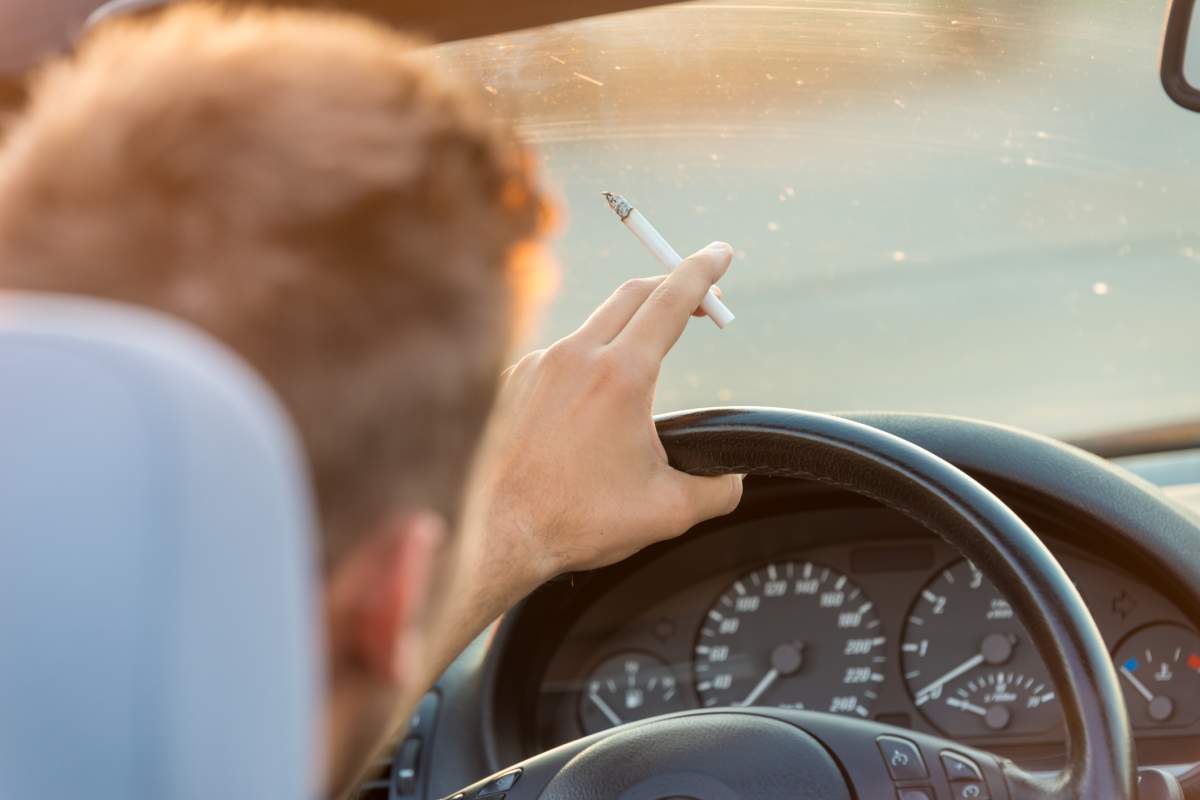 Man with cigarette in car.