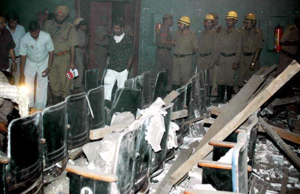 Indian police officers and investigators inspect the damage to the interior of the Liberty Cinema Hall in New Delhi,22 May 2005. after a series of bombs exploded at cinema halls in the Indian capital.