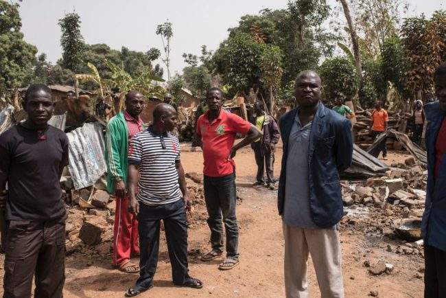 This Feb. 24, 2017 photo shows men standing among rubbles in the village of Bakin Kogi in Nigeria's Kaduna state after an attack. 