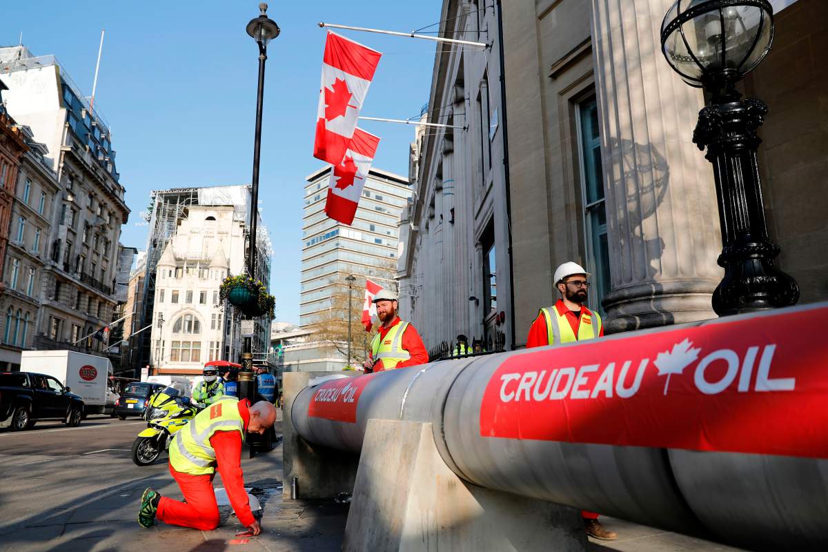 Demonstrators use a mock oil pipeline to block the entrance to the Canadian Embassy in central London on April 18, to protest the Trans Mountain pipeline project.