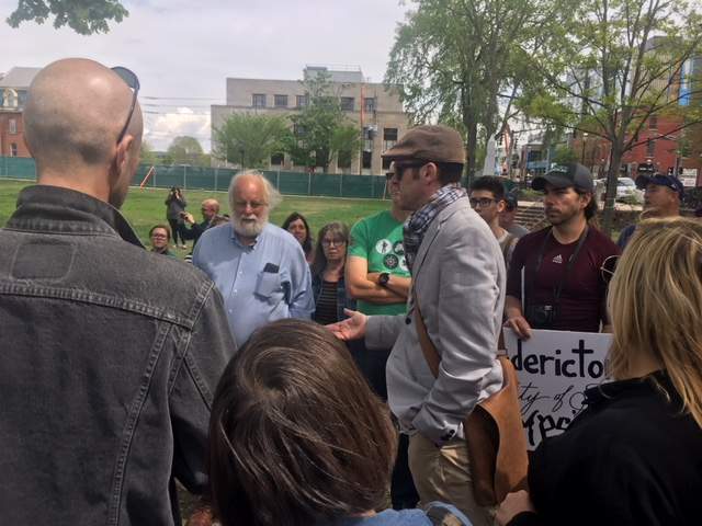 Fredericton councillor John MacDermid speaks with residents at the rally.