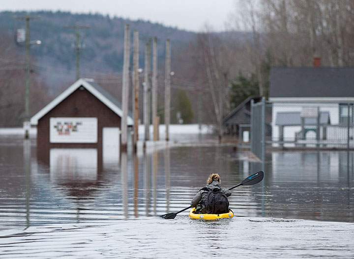 A resident paddles her kayak at Darlings Island, N.B. on Thursday, May 3, 2018 as the Kennebecasis River flooded the only road into the community.
