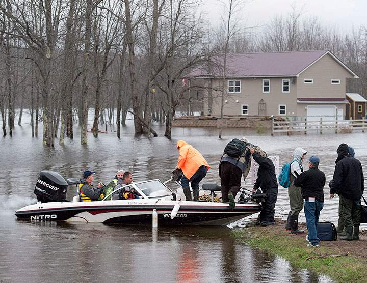 Rob Dekany, known locally as Uber Rob, ferries stranded passengers at Darlings Island, N.B. on Thursday, May 3, 2018 as the Kennebecasis River flooded the only road into the community.