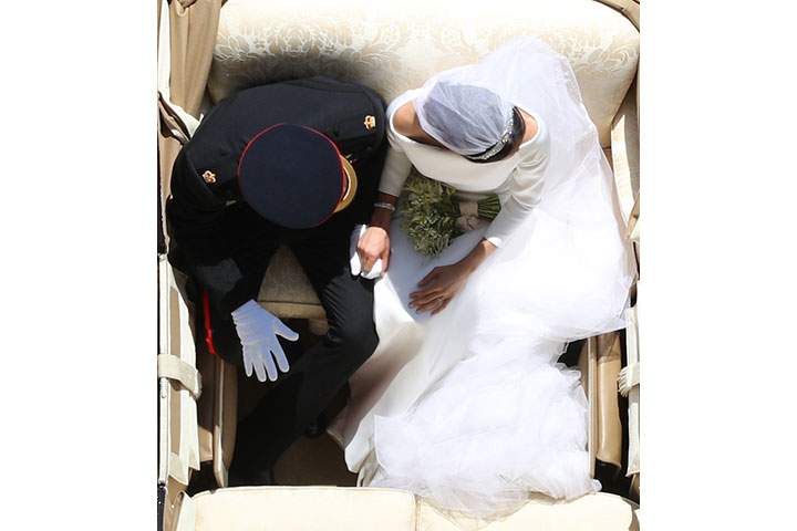 Prince Harry, Duke of Sussex and the Duchess of Sussex hold hands in the Ascot Landau Carriage as their carriage procession rides along the Long Walk, on May 19, 2018 after their wedding ceremony.