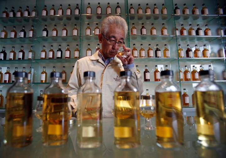 In this March 8, 2017 photo, Suntory’s chief blender Shinji Fukuyo demonstrates how he examines the whisky at the Suntory distillery in Yamazaki, near Kyoto, western Japan.