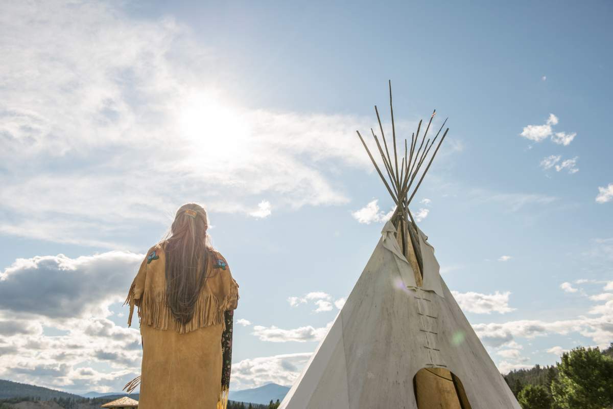A Ktunaxa elder in regalia next to a teepee at St Eugene Golf Resort, near Cranbrook.