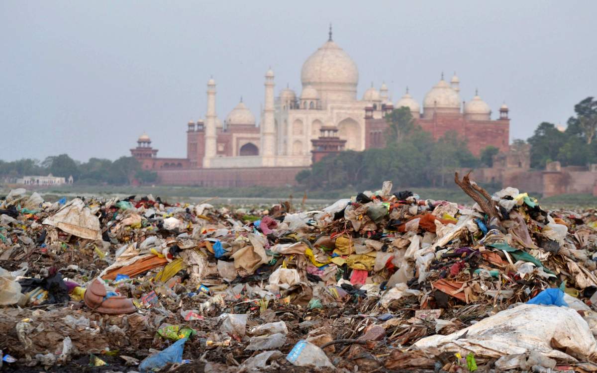In this Friday, May 11, 2018 photo, garbage covers the area by the Yamuna river near the Taj Mahal in Agra, India.