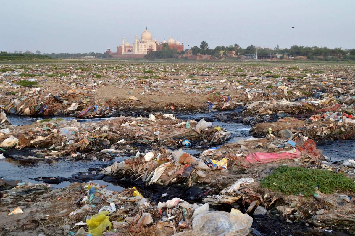 In this Friday, May 11, 2018 photo, garbage covers the area by the Yamuna river near the Taj Mahal in Agra, India.