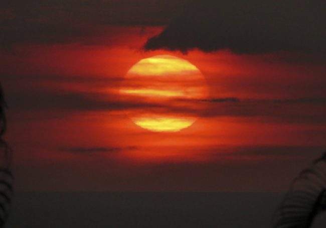 The sun sets through “vog” or volcanic smog in Kailua-Kona, Hawaii, May 23, 2018.