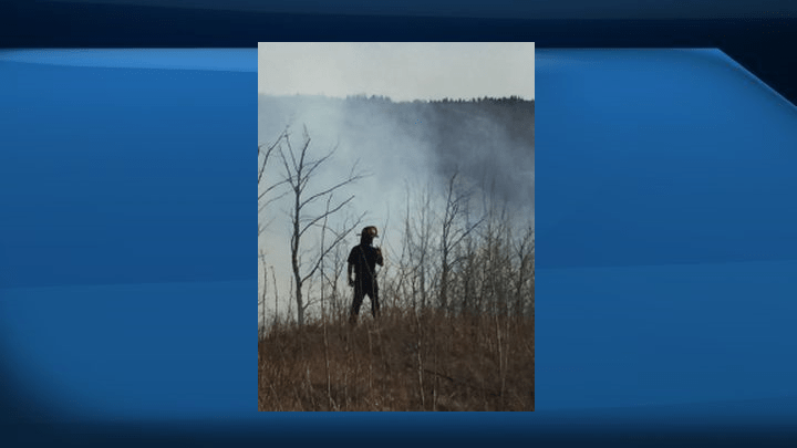 Firefighters monitor a grass fire in Windermere Saturday.