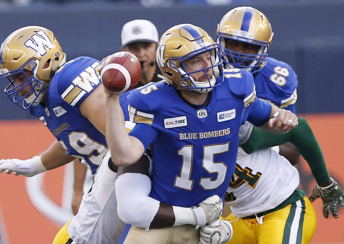 Winnipeg Blue Bombers quarterback Matt Nichols (15) gets hauled down by Edmonton Eskimos’ Darius Allen (99) during the first half of pre-season CFL action in Winnipeg Friday, June 1, 2018.