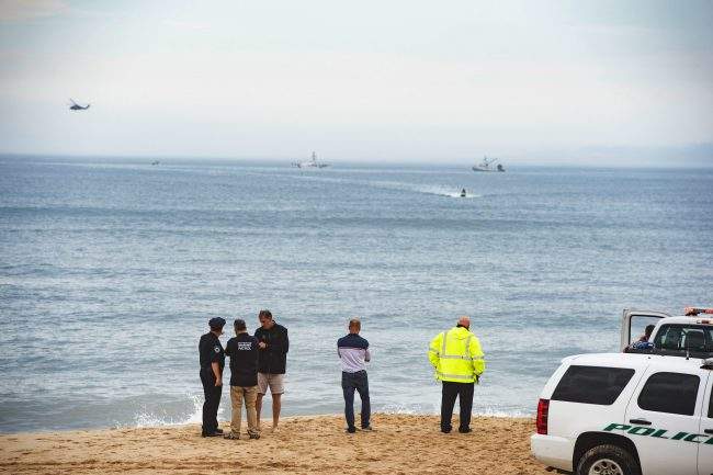 Members of the New York State park police look near the scene of a plane crash in the ocean off Indian Wells Beach in Amagansett, N.Y.,June 2, 2018. 
