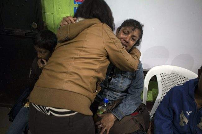 Ruth Rivas, who says she has two missing children, is consoled by a neighbor in a shelter near the Volcan de Fuego or Volcano of Fire in Alotenango, Guatemala, Sunday, June 3, 2018.