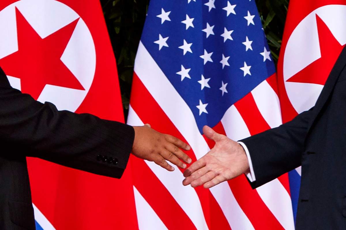 U.S. President Donald Trump, right, reaches to shakes hands with North Korea leader Kim Jong Un at the Capella resort on Sentosa Island Tuesday, June 12, 2018 in Singapore.