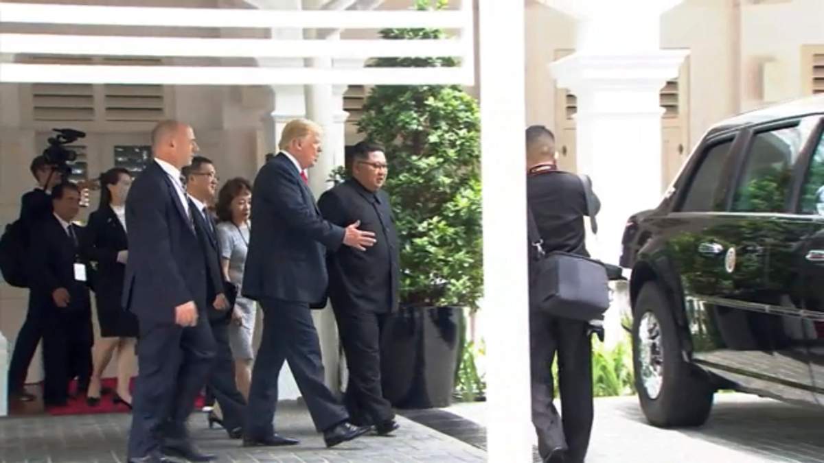 In this image made from video provided by Host Broadcaster Mediacorp Pte Ltd, U.S. President Donald Trump shows North Korean leader Kim Jong Un, center, his presidential vehicle outside the Capella Hotel in Singapore, Tuesday, June 12, 2018.