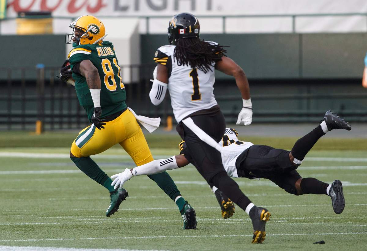 Hamilton Tiger-Cats Don Unamba (1) and Richard Leonard (4) try to catch Edmonton Eskimos D'haquille Williams (81) during first half CFL action in Edmonton, Alta., on Friday June 22, 2018. 