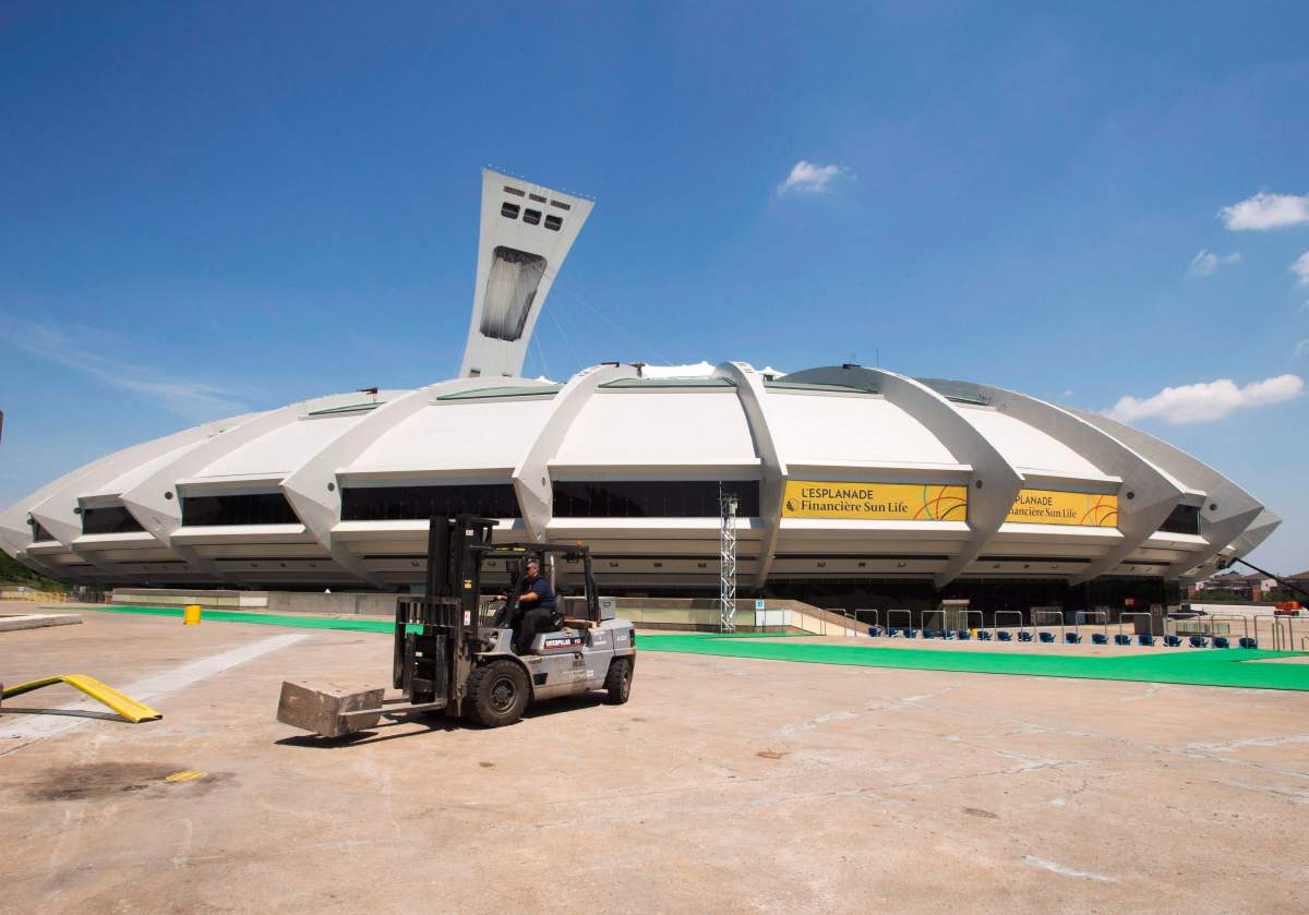 A worker does some maintenance in front of Olympic Stadium Wednesday, July 6, 2016 in Montreal.