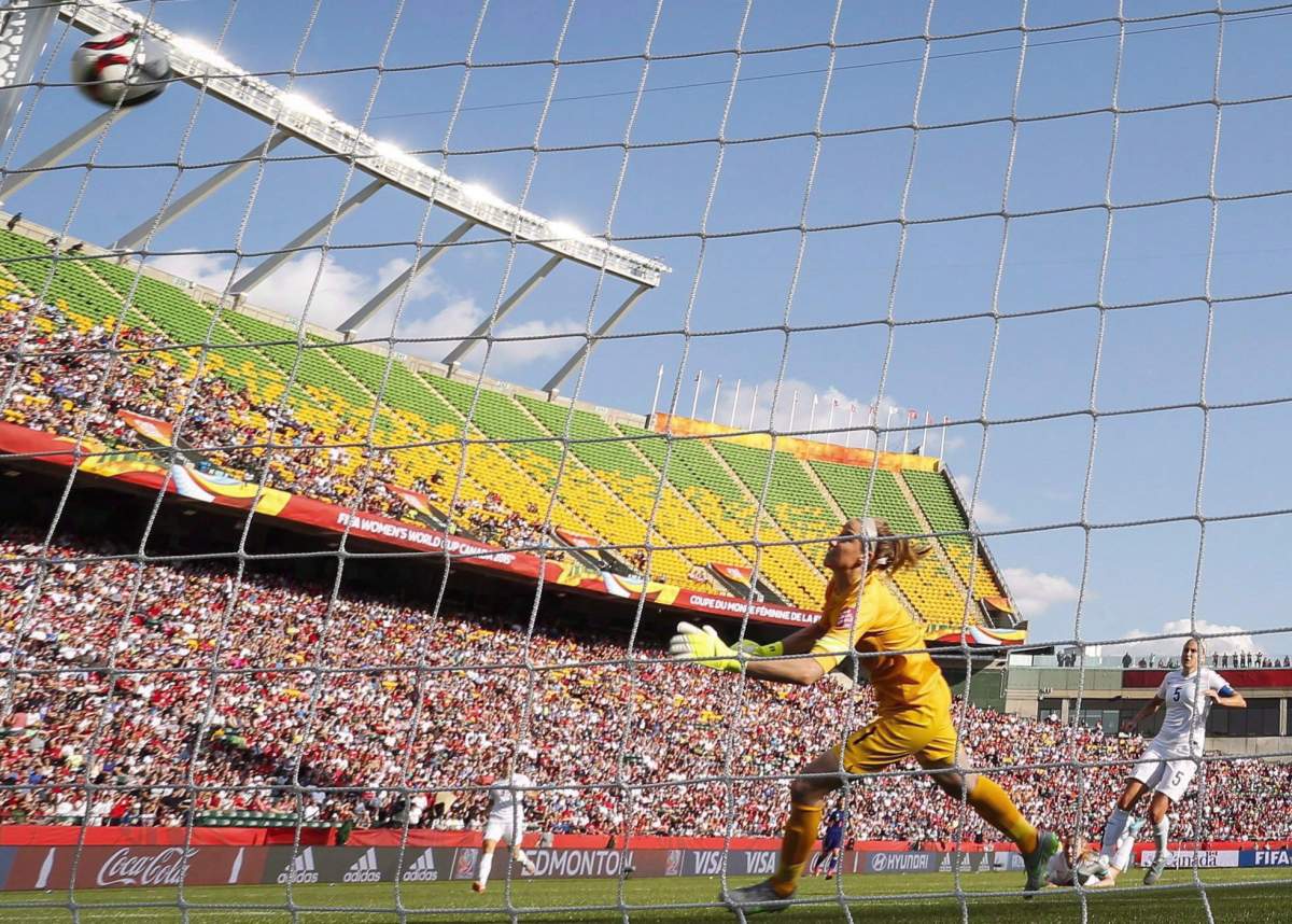 England goalkeeper Karen Bardsley, left, tries to prevent the ball from entering the net on a kick from teammate Laura Bassett, on ground centre, as Steph Houghton (5), second from right, and Japan’s Yuki Ogimi (17) look on during first half FIFA Women’s World Cup semi-final soccer action in Edmonton, Alta., Wednesday, July 1, 2015.
