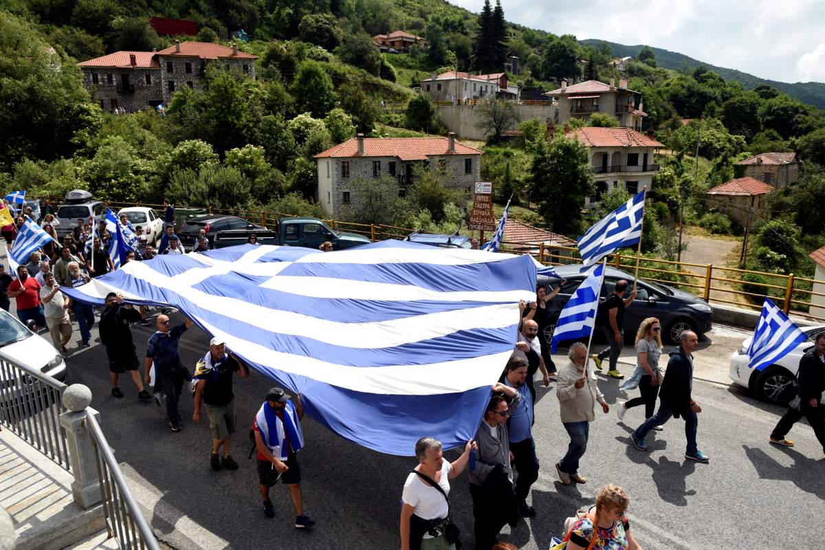 Protesters carry a giant Greek national flag during a demonstration against the agreement reached by Greece and Macedonia to resolve a dispute over the former Yugoslav republic’s name, in Pisoderi village, northern Greece, June 17, 2018. REUTERS/Alexandros Avramidis