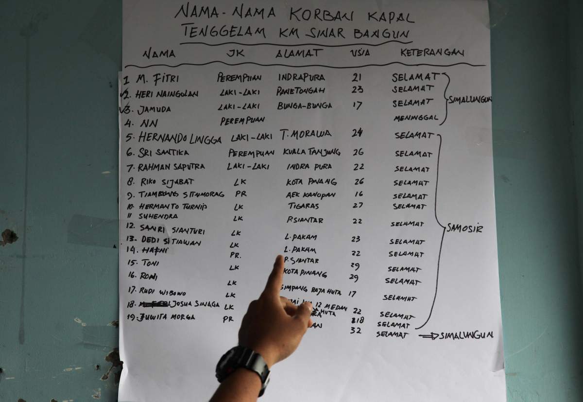 An Indonesian soldier points to a list of passengers who survived at a ferry accident on Lake Toba, a popular tourist destination.