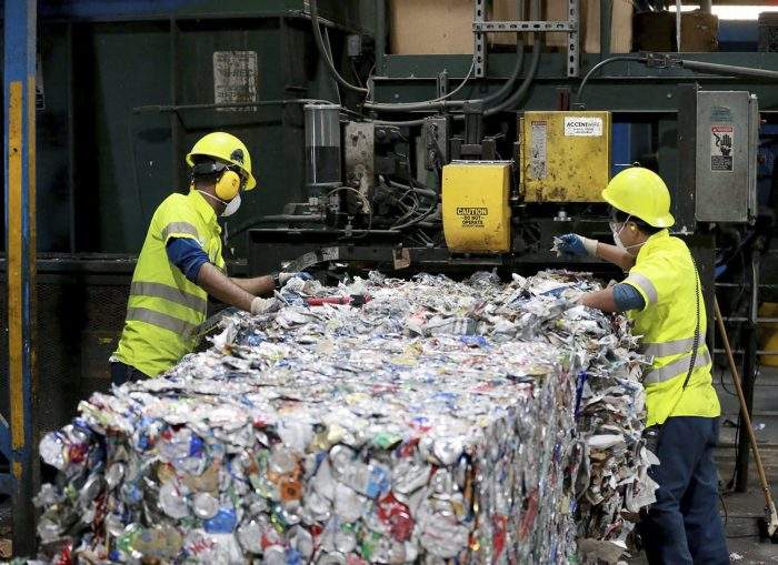 In this Thursday, Nov. 2, 2017 file photo, workers at ACUA recycling center pull plastic contaminants out of the recycling stream in Egg Harbor Township, N.J.