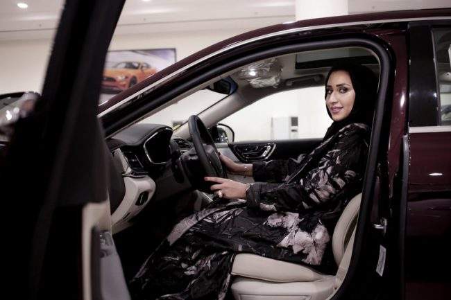 Saleswoman Maram Al-Hazer poses for a photograph inside a Lincoln Continental at the Al-Jazirah Ford showroom in Riyadh, Saudi Arabia, June 21, 2018.