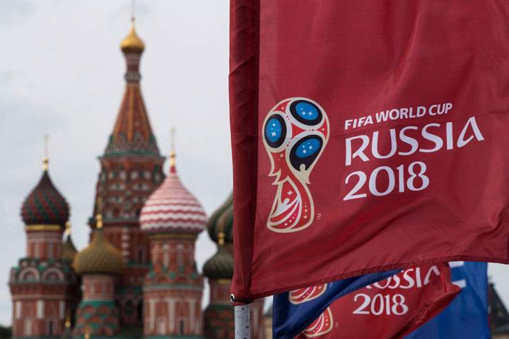 In this June 4, 2018, file photo, a flag with the logo of the World Cup 2018 on display with the St. Basil's Cathedral in the background, in Moscow, Russia. 