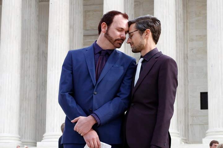 In this Dec. 5, 2017 file photo, Charlie Craig, left, and David Mullins touch foreheads after leaving the Supreme Court in Washington. The Supreme Court is setting aside a Colorado court ruling against a baker who wouldn’t make a wedding cake for the same-sex couple.