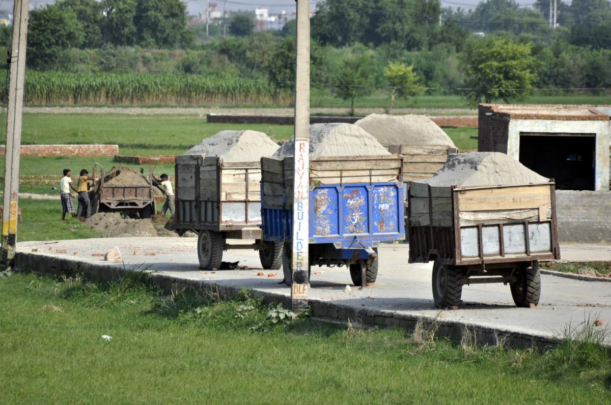 Trolleys filled with sand, bee-lined at Badarpur village near Loni on Aug. 3, 2013, in Ghaziabad, India. After Gautam Budh Nagar, Ghaziabad is fast emerging as an illegal sand mining hub in the NCR. There is huge demand for illegally mined sand, as it is cheap because the so-called “sand mafia” don’t have to pay a royalty to the administration.
