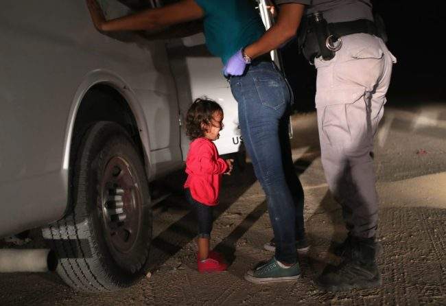 MCALLEN, TX – JUNE 12: A two-year-old Honduran asylum seeker cries as her mother is searched and detained near the U.S.-Mexico border on June 12, 2018 in McAllen, Texas. The asylum seekers had rafted across the Rio Grande from Mexico and were detained by U.S. Border Patrol agents before being sent to a processing center for possible separation.