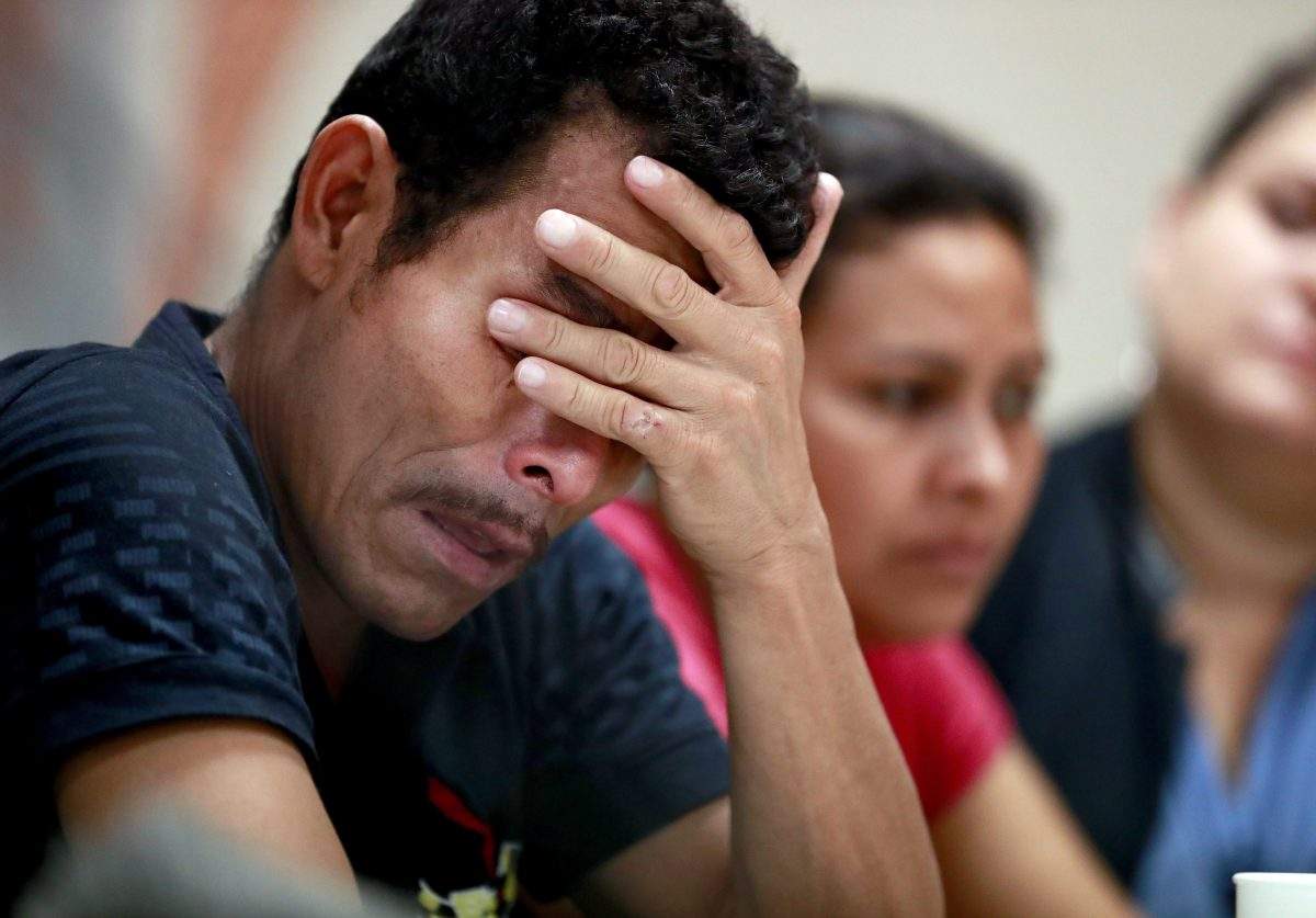 FILE - Melvin, foreground, and Iris, both from Honduras, listen as they hear other immigrants tell of their separation from their children at the border during a news conference at the Annunciation House, Monday, June 25, 2018, in El Paso, Texas.