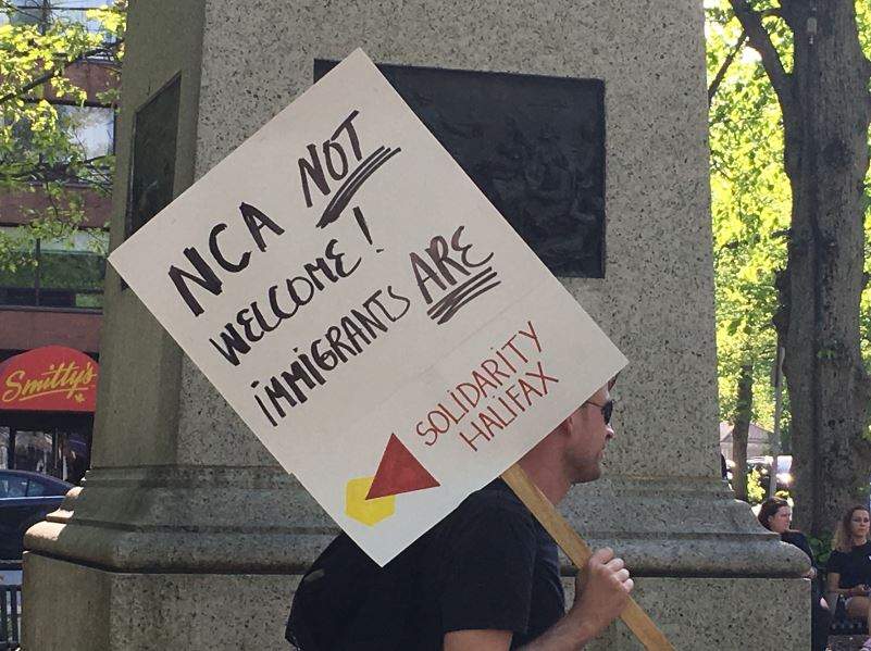 A protester holds up a sign at Victoria Park in Halifax ahead of a planned rally by the National Citizens Alliance. 