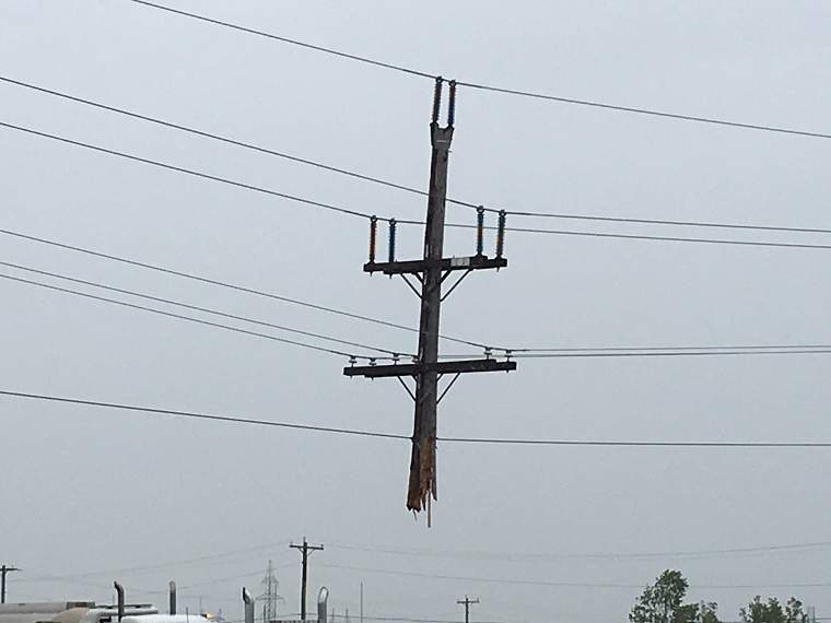 A hydro pole dangles from the wires after a semi crashed into it.