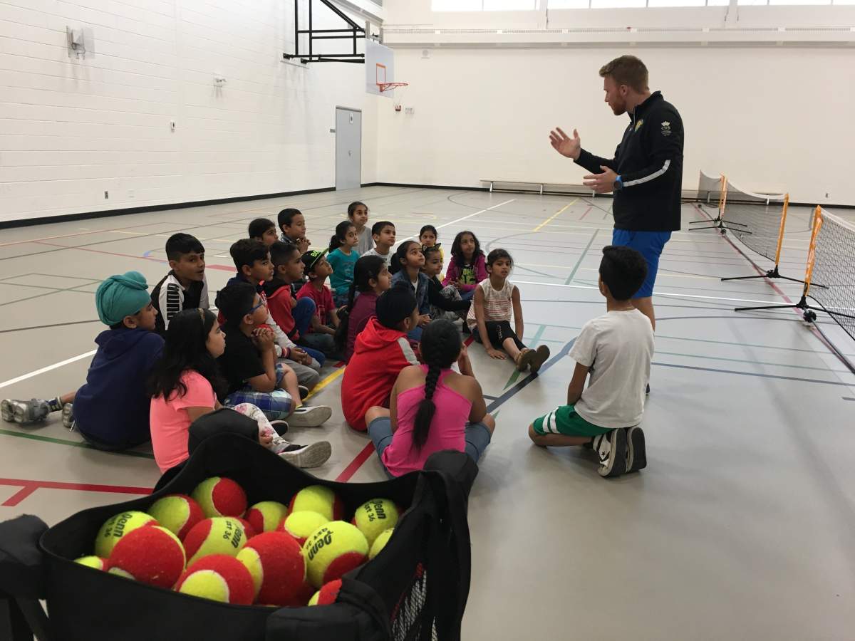 Greig Ewing from The Alberta Tennis Centre teaches tennis to grade 3 students at Hugh A. Bennett school in Calgary. June 22nd, 2018.