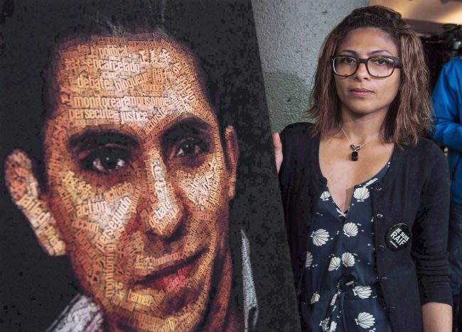 Ensaf Haidar stands next to a poster of a book of articles written by her husband, the imprisoned Saudi blogger Raif Badawi, in Montreal, June 16, 2015.
