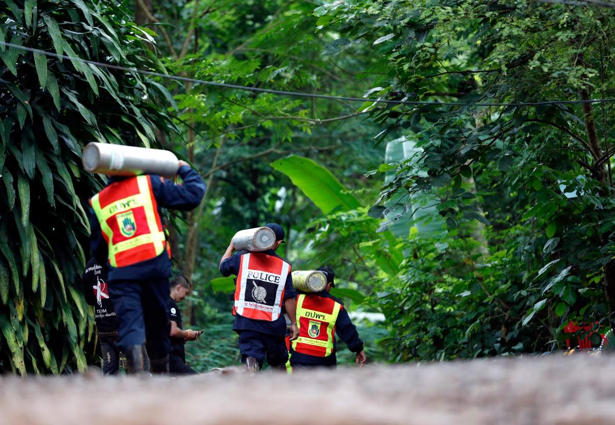 Members of Thai rescue team carry oxygen tanks during rescue operations to save a soccer team from Tham Luang cave in Khun Nam Nang Non Forest Park, Chiang Rai province, Thailand, 03 July 2018.