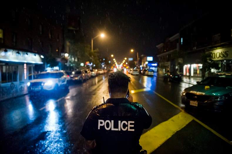 Police are seen around the scene of a shooting in east Toronto, on Monday, July 23, 2018. 