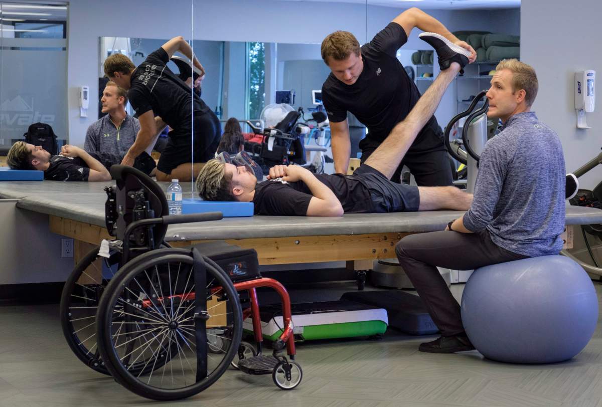 Humboldt Broncos bus crash survivor Ryan Straschnitzki, attends physio session with Kinesiologist Kirill Dubrovskiy, centre, and physiotherapist Nelson Morela, right, in Calgary, Alta., Monday, July 16, 2018.