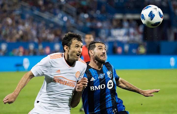 Atlanta United's Michael Parkhurst, left, challenges Montreal Impact's Ignacio Piatti during second half MLS soccer action in Montreal, Saturday, July 28, 2018. 
