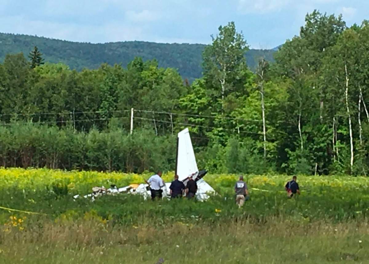 This photo provided by WVII-TV/ABC7 shows the tail of a small plane that crashed near Greenville Municipal Airport in Greenville, Maine, Monday, July 30, 2018.