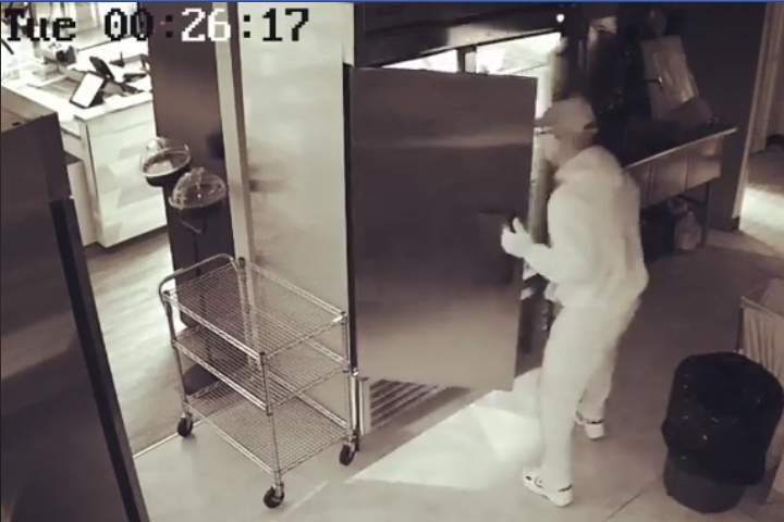 A man is seen rummaging through the fridge at Fromagerie Bothwell Tuesday.