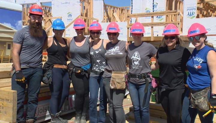 Volunteers from Global Saskatoon roll up their sleeves in a partnership with Habitat for Humanity on Tuesday.