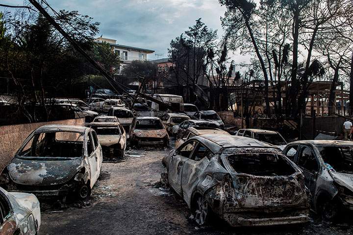 This photo taken on July 24, 2018 show cars burnt following a wildfire at the village of Mati, near Athens, on July 24, 2018.