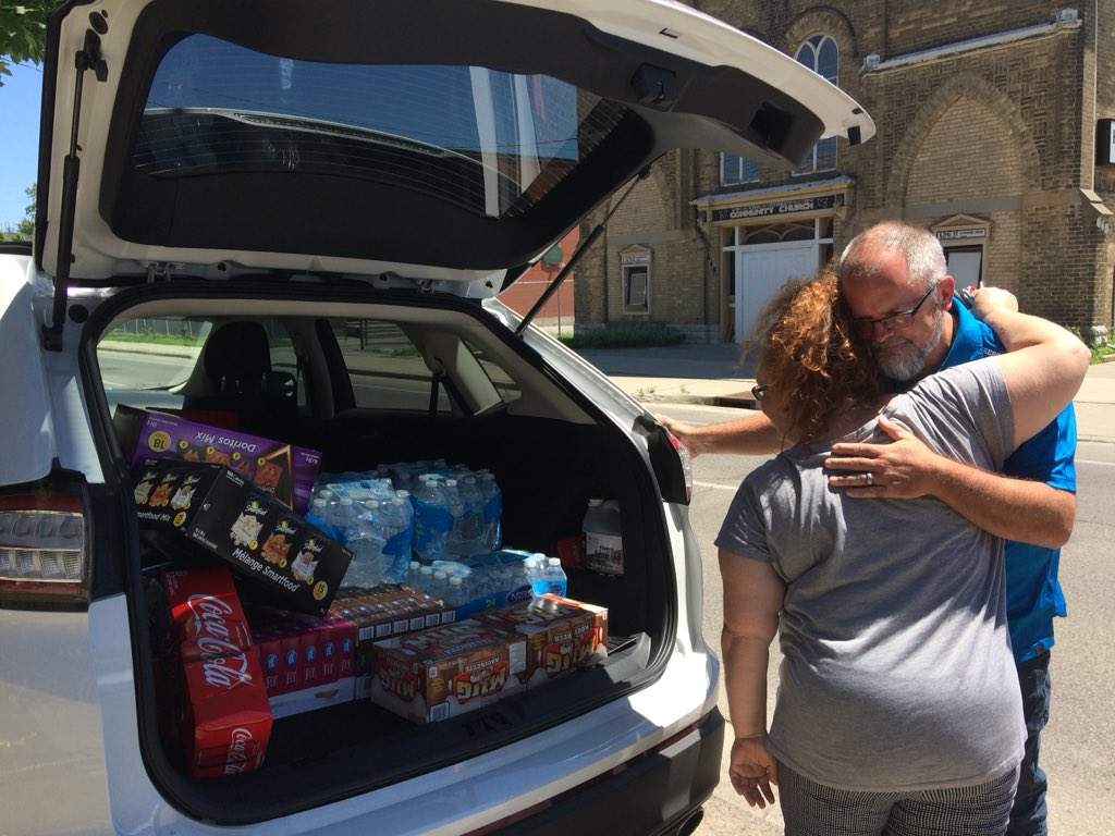 JoDee Durrant-Pheonix gives Bill Norris a hug, after he brings a donation of drinks and snacks for the displaced families. 