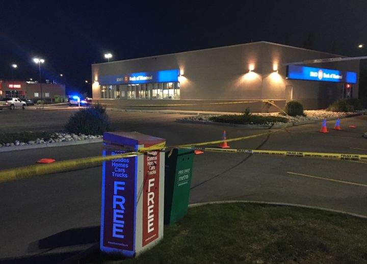Police tape can be seen at a north Edmonton bank in the area of 97 Street and 160 Avenue near where a liquor store employee was reportedly stabbed while trying to confront a thief.
