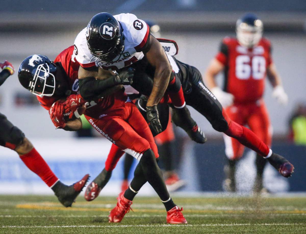 Ottawa Redblacks' Kyries Hebert, right, slams into Calgary Stampeders' DaVaris Daniels, during second half CFL football action in Calgary, Thursday, June 28, 2018.