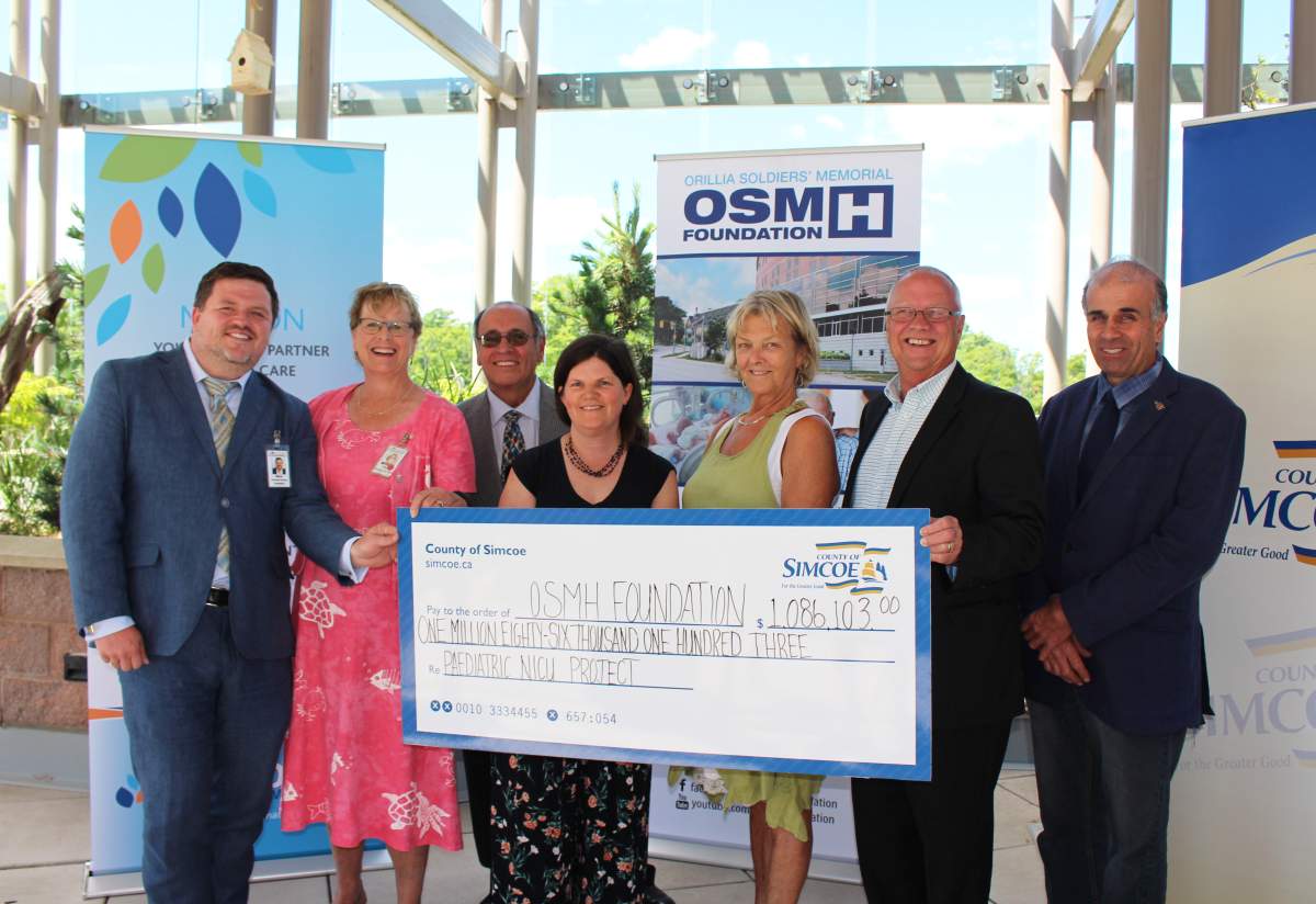 Simcoe County Warden Gerry Marshall presents a $1 million cheque to the Orillia Soldiers' Memorial Hospital July 11.